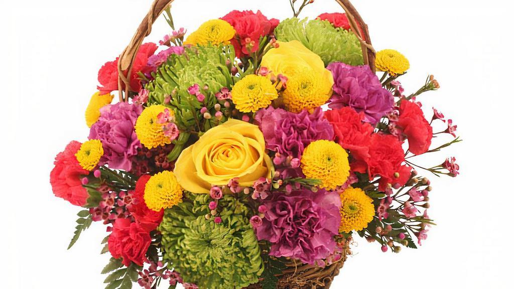 Colorfulness · Color is the name of the game in this blooming basket. From sunshine yellow roses and daisy poms to hot pink and lavender carnations, colorfulness truly packs a punch. Send some color their way today and brighten up the world!

includes:
round twiggy vine basket with handle and liner, foliage: leather leaf, green Fuji spider mums, yellow roses, lavender carnations, yellow button poms, hot pink mini carnations, lavender waxflowers.