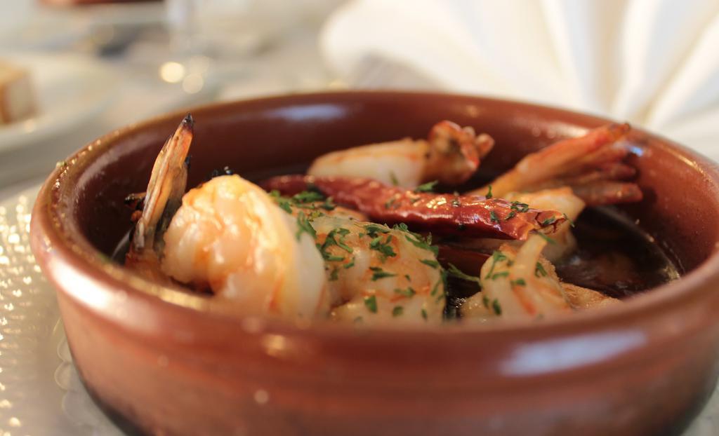 Gambas Al Ajillo · Gluten free. Sautéed shrimp in extra virgin olive oil, fresh roasted garlic, and brandy.