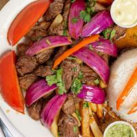 Lomo Saltado · Filet mignon sautéed with onions and tomatoes. Served over French fries and rice.