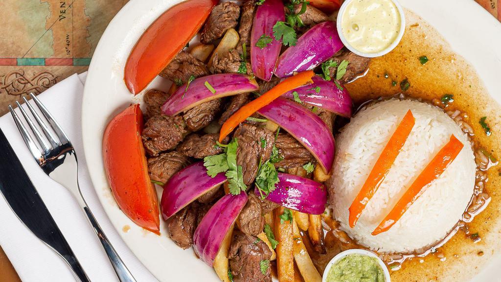 Lomo Saltado · Filet mignon sauteed with onions and tomatoes. Served over french fries and rice.