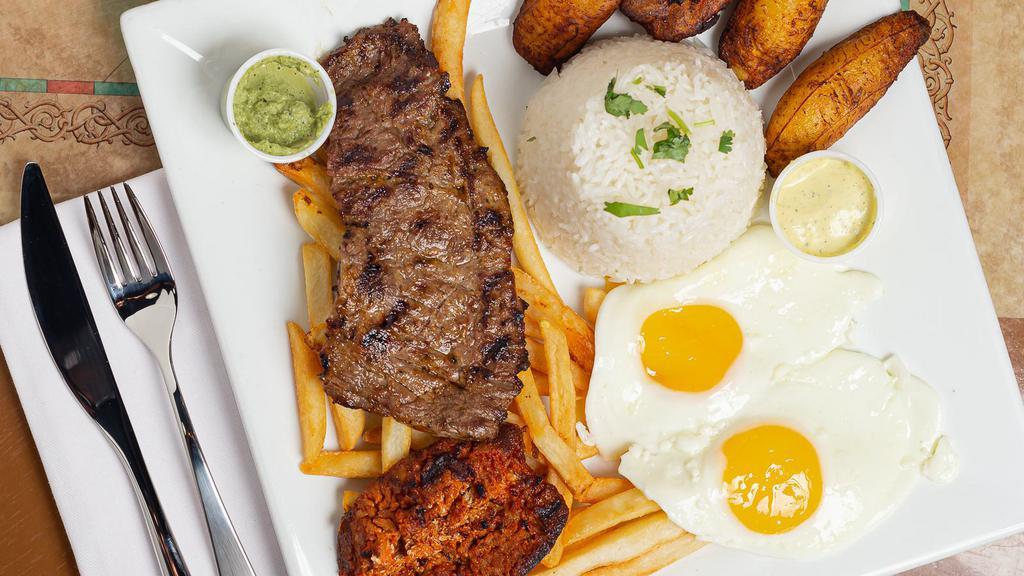 Bisteck A Lo Pobre · Tender steak, fried plantain and fried eggs served over French fries and rice.