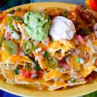 South Of The Border Nachos · Corn tortilla chips with melted Monterey Jack cheese, topped with beans pico de gallo, sour ...