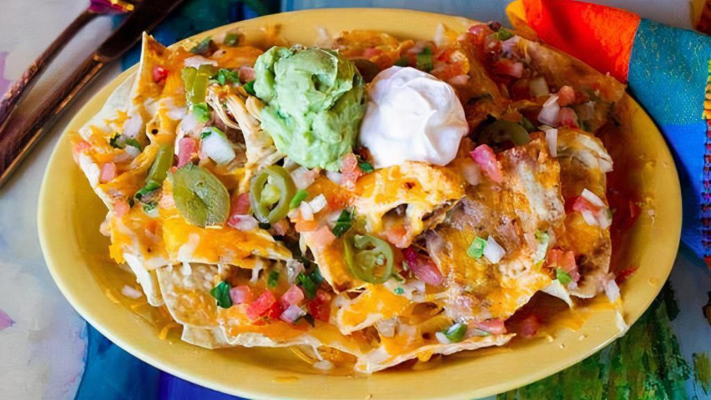 South Of The Border Nachos · Corn tortilla chips with melted Monterey Jack cheese, topped with beans pico de gallo, sour cream, guacamole, jalapenos and choice of beef or chicken.
