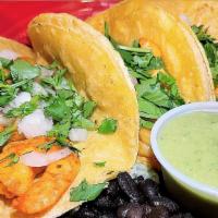 Shrimp Street Tacos · Three grilled shrimp tacos topped with cilantro, onions along with avocado sauce, served wit...