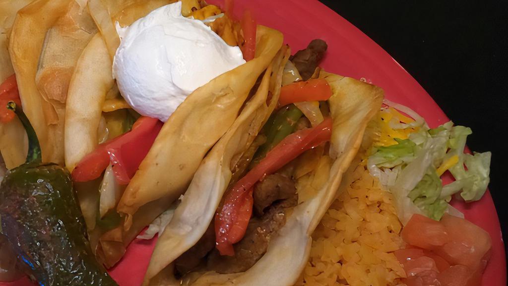 Puffy Fajita Dinner · Two deep-fried flour tacos stuffed with your choice of protein, red, green grilled peppers, onions, served with rice and beans.