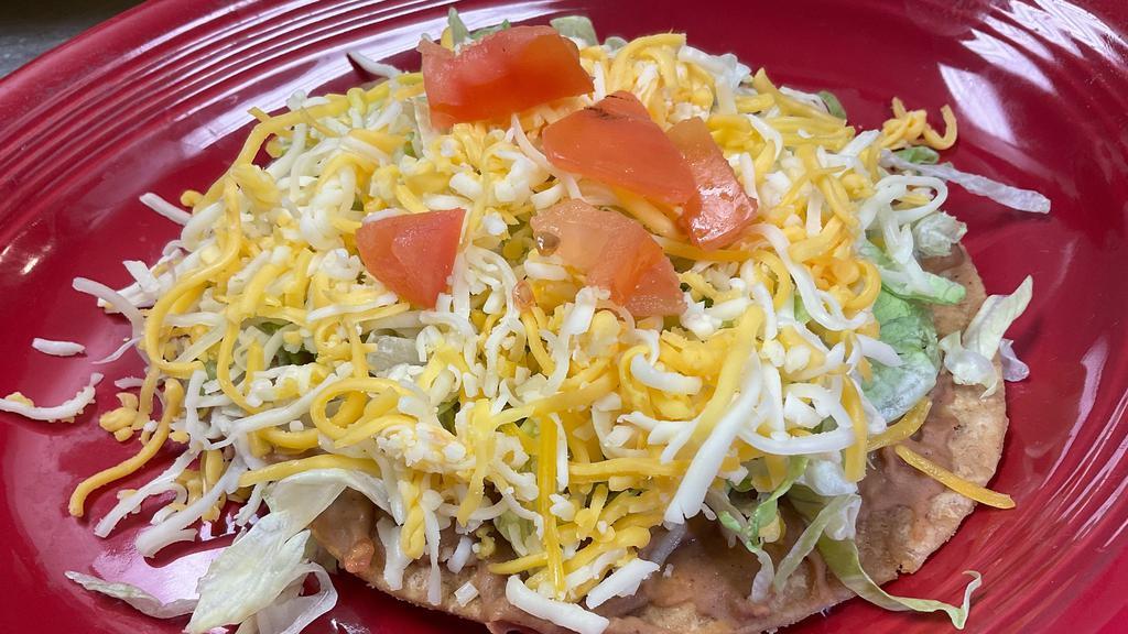  Tostada  · Bean tostada topped with lettuce, cheese, tomato