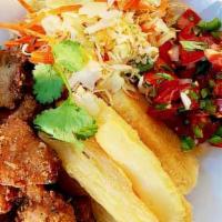Yuca Con Chicharrones · Fried cassava, topped with fried pork, served with marinated cabbage and sauce.
