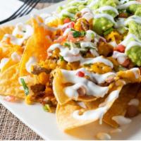 Nachos De Pollo / Chicken Nachos · served w/ beans, onions, tomatoes, sour cream, cheese, jalapeño, and guacamole.