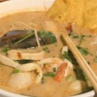 Seafood Creamy Noodle Soup Tom · Yum soup with shrimp, squid, green mussel, scallop, and rice noodles.