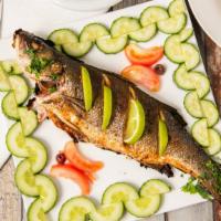 Baked Branzino · Marinated Branzino baked with lemon and oil, served with rice and salad.