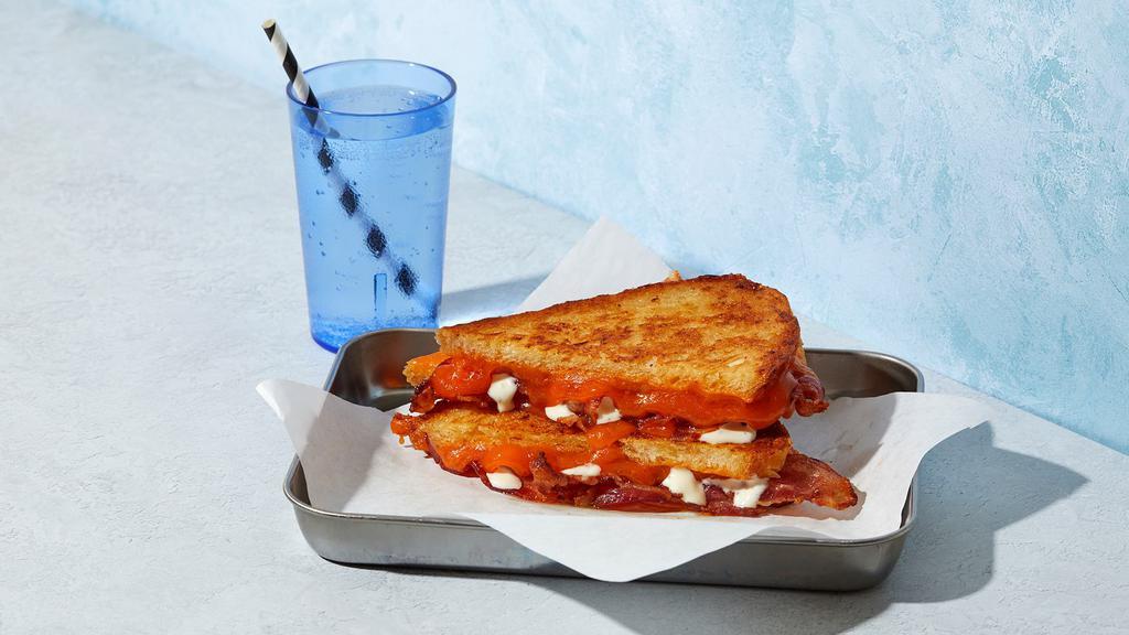 The Bacon Cheddar Ranch · Melted Cheddar cheese with bacon and ranch grilled between two slices of buttered bread.
