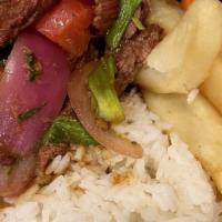 Lomo Saltado · Peruvian style beef tenderloin stir fry served with red and green onions, tomato, cilantro, ...