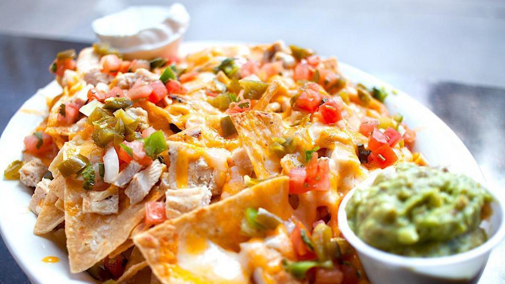 Nachos · Tortilla chips topped with seasoned ground beef, chicken or both, plus melted cheddar & jack cheeses, pico de gallo and jalapeños. Sour cream and guacamole on the side.