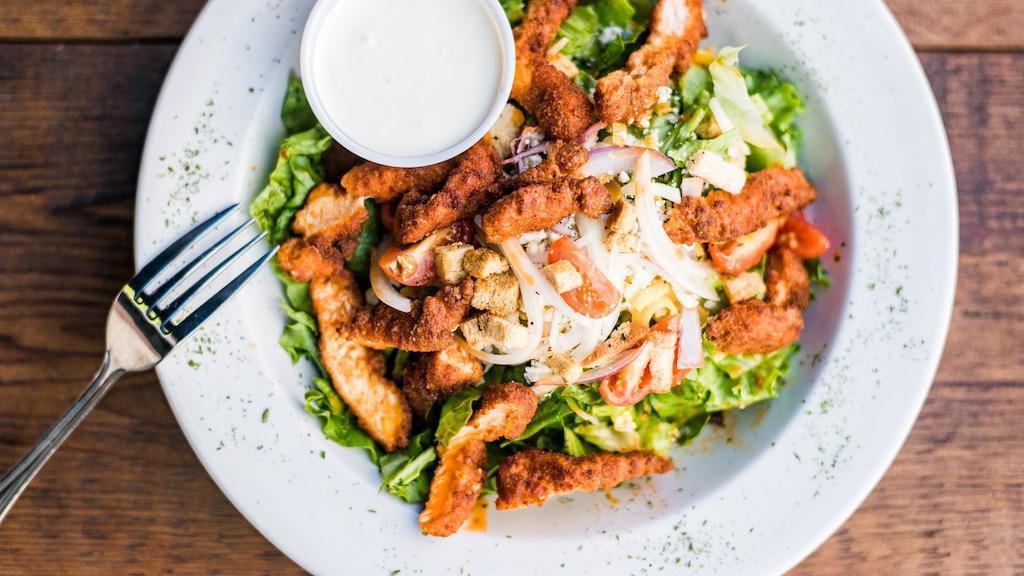 Buffalo Chicken Salad · Leafy greens topped with buffalo chicken strips, red onions, tomatoes and bleu cheese crumbles. Bleu cheese dressing on the side.