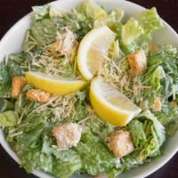 Caesar Salad · Romaine lettuce tossed with Caesar dressing, croutons, lemon, and parmesan cheese.