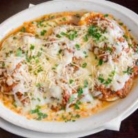 Baked Ravioli Pasta · Meat stuffed pasta covered with bolognese sauce, mozzarella, and parmesan. Served with garli...