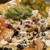 Loco Nachos · Crispy colorful tortilla chips, grilled chicken, steak and shrimp, black beans, queso dip, t...