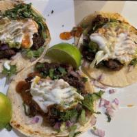 Tacos De La Calle
 · 4 tacos. Spicy or regular. Your choice of grilled chicken breast, seasoned ground beef, shre...