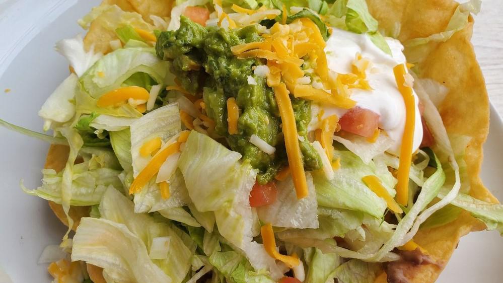 Taco Dorados · 2 Crispy pan fried tacos with choice of shredded chicken or shredded beef, layered with cheese, lettuce, tomatoes, & onions