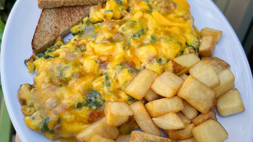 Protein Lover’S Scramble · Three eggs scrambled with grilled chicken, bacon, cheddar cheese & spinach, served with toast & breakfast potatoes or fresh fruit salad
