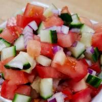 Shirazi Salad · Minced tomato, cucumber, and onion, dressed with olive oil and lemon juice, garnished with d...