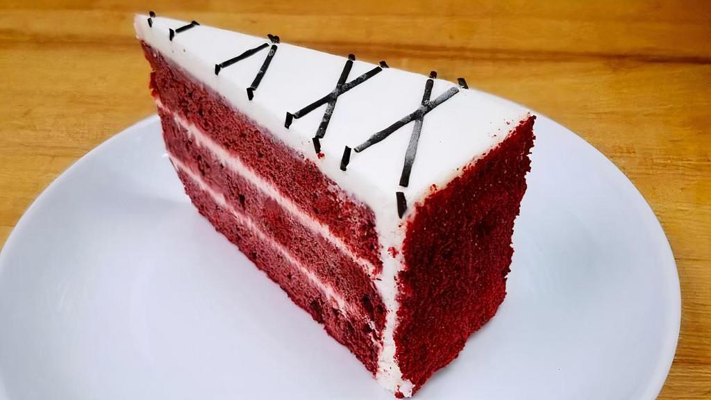 Red Velvet · A red hued chocolate layer cake, filled and iced with a smooth cream cheese frosting, finished with chocolate drizzle and surrounded by red velvet cake crumbs