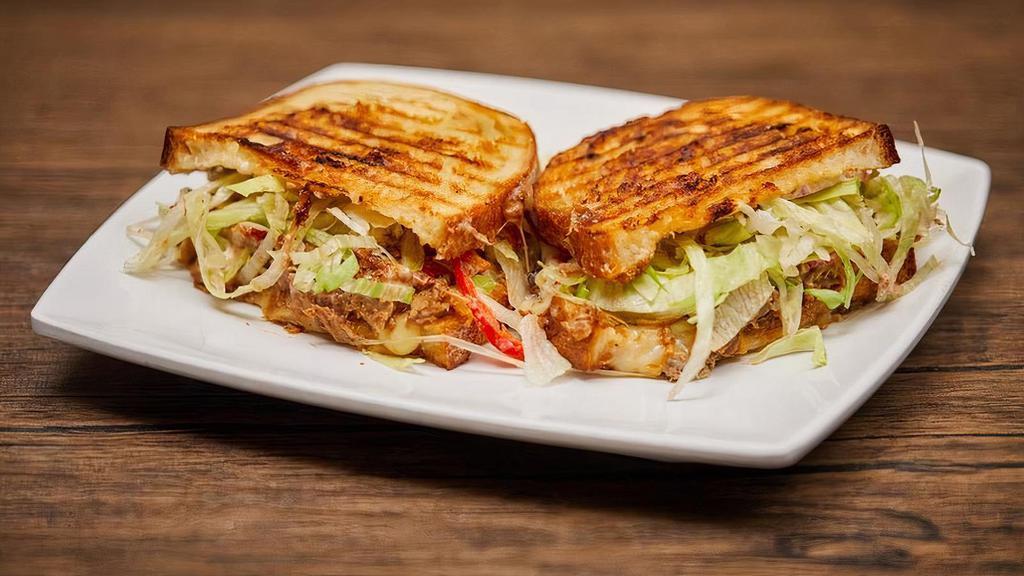 Bbq Pulled Pork Panini · Zesty BBQ dressed pulled pork, topped with melty pepper jack, tomato, and shredded lettuce.