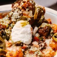 Trudy'S Taco Tots · Tater tots topped with queso, spiced beef, pico, sour cream, pickled jalapenos, avo salsa, a...