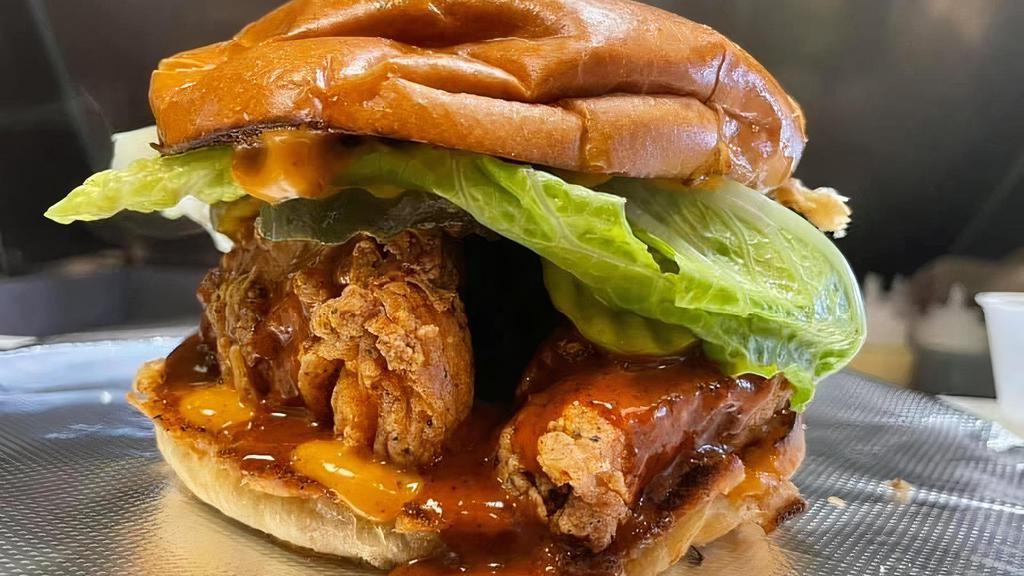 Nashville Hot Chicken Sandwich · Crispy, Fried, chicken tenders smothered in Nashville Hot sauce and topped with lettuce, pickles and a house mayo sauce.
