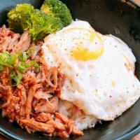 Kalua Pork Rice · Slow cooked pulled pork, broccoli, fried egg, barbecue sauce, scallions, chili powder.