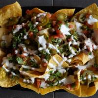 Nuclear Nachos · Our in house made tortilla chips served with pico de gallo, sour cream, jalapeños, and our c...