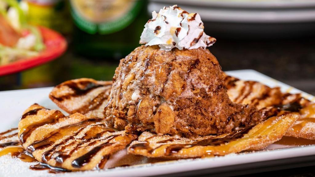 Fried Ice Cream ⭐️ · A giant scoop of deep-fried vanilla ice cream served on a homemade flour tortilla topped with whipped cream, dusted with cinnamon and sugar, and drizzled with chocolate and caramel.