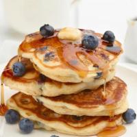 Blueberry Pancakes · Two large buttermilk blueberry pancakes served with syrup and butter.