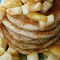 Pear Pancakes · Two large caramelized pear buttermilk pancakes with syrup and butter.