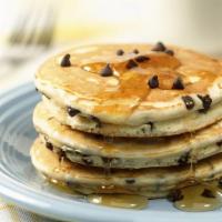 Chocolate Chip Pancakes · Two large chocolate chip pancakes with syrup and butter.