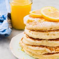 Lemon Pancakes · Two large buttemik lemon pancakes served with butter and syrup.