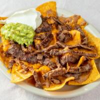 Bean And Cheese Nachos · Corn tortilla chips with refried beans and melted cheddar cheese. You can also add Asada, Gu...