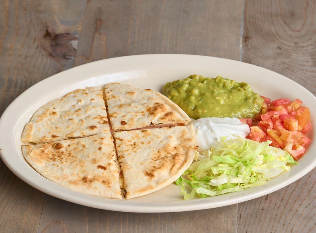 Sincronizada · Ham and cheese quesadilla between two flour tortillas. Served with lettuce, tomato, guac, and sour cream.