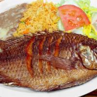 Mojarra Frita · A lightly seasoned, whole fried tilapia fish served with salvadorean rice, fried beans, smal...