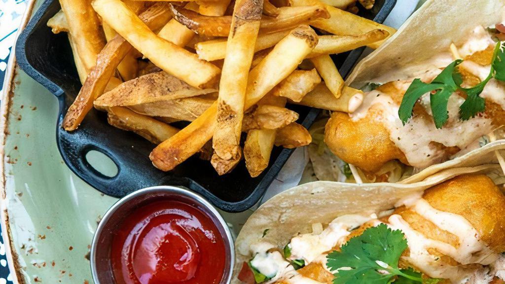Crispy Fish Tacos · cod, cabbage slaw, white cheddar, pico de gallo, chipotle  buttermilk herb dressing, corn tortillas. Served with stewed black beans and choice of side.