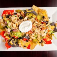 Loaded Nachos · Fresh fried to order tricolor corn tortilla chips with spicy queso fresco, lettuce, black be...