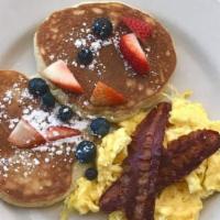 Pancake Combo · Fresh Scramble eggs served with 2 sweet cram pancakes, topped with berries and sugar powder,...