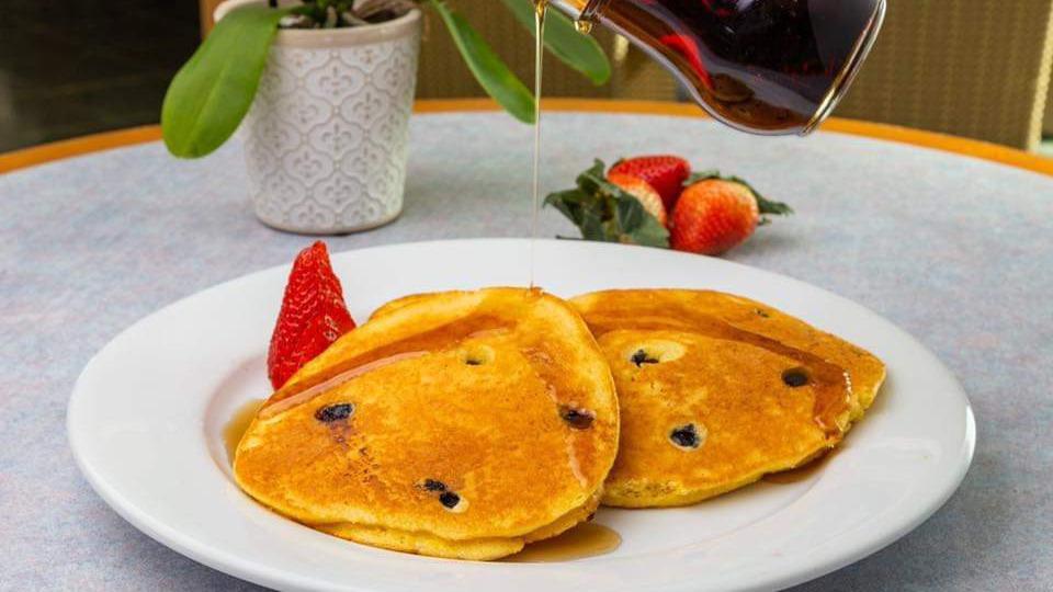 Blueberry Corn Cakes · Three of our famous made from scratch blueberry corn cakes topped with fresh cut strawberries. 498 calories 8 grams of protein, 6 grams of fiber, 27 grams of sugar, 85 grams of carbohydrates, and 9 grams of fat.