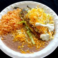 #12 2 Chiles Rellenos · Two chile rellenos topped with enchilada sauce, cheese, lettuce, and sour cream. Served with...