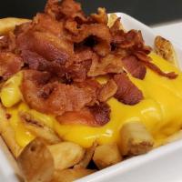 Bacon And Cheese Fries · Skin-on french fries cooked to golden perfection served with hot cheddar cheese sauce and to...