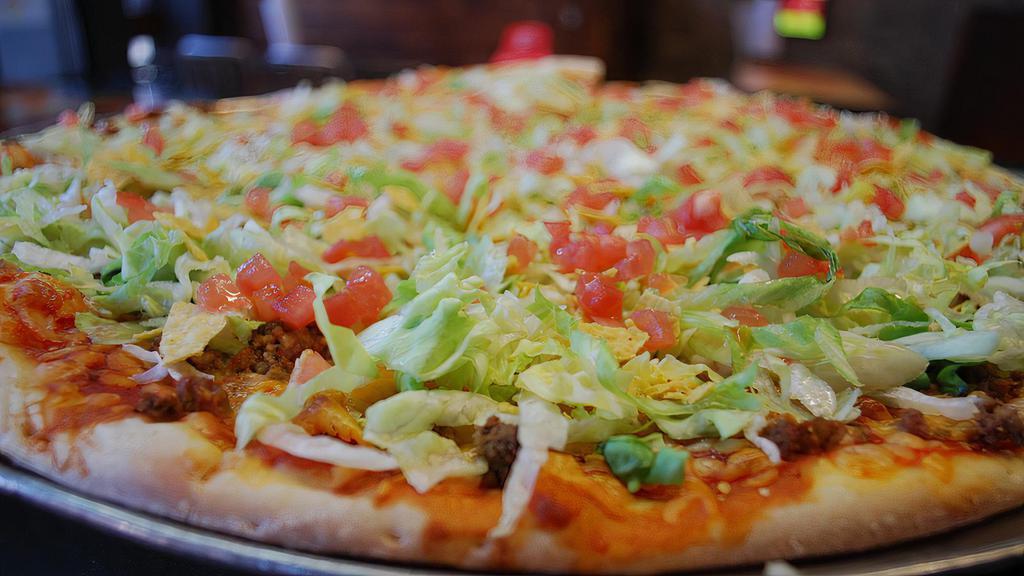 Taco Pie · If you’re craving something Taco, then order right now! Your Taco Pizza comes with a taco meat, crushed tortilla chips, shredded colby cheese, tomatoes, lettuce, and our signature Red Grinder Sauce. Don’t let this one slip on by. Choice of taco meat or shredded chicken.