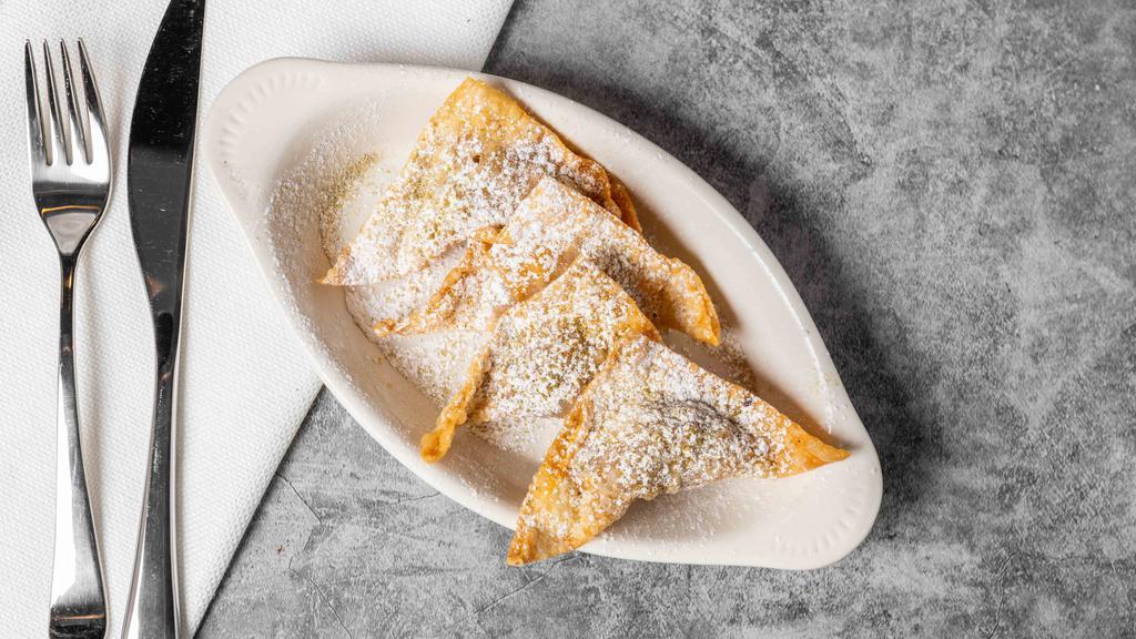 Sambosa · Pan-fried turnovers stuffed with minced beef and lentils, topped off with powdered sugar and ground cardamom.