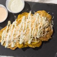 Tostones · Plantain chips topped with  monterey jack cheese and pink mayo sauce (5 per serving)