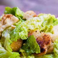 Caesar Salad · Gluten-free. Heart of romaine lettuce, garlic croutons, and Parmesan cheese, topped with a c...