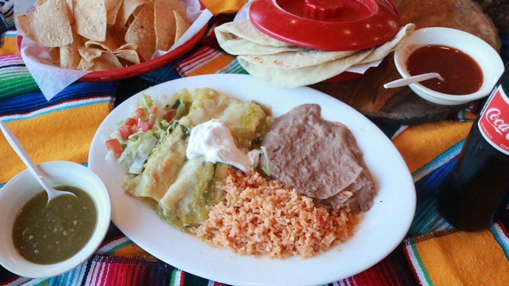 Green Enchiladas · Chicken enchiladas with tomatillo sauce and sour cream, rice, beans and salad.